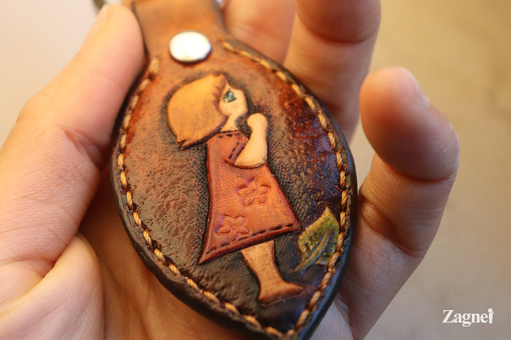 leather keyring featuring a carved girl